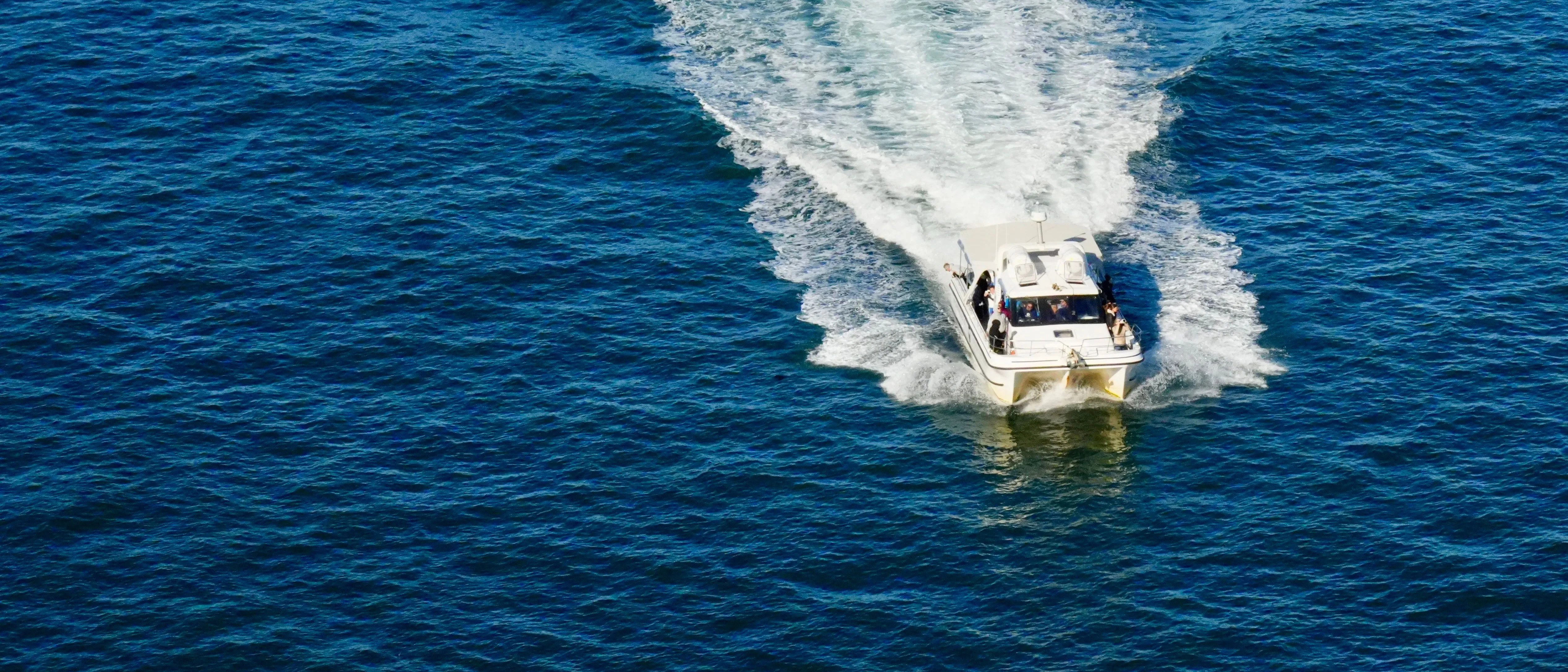 A charter boat running out to open water with passengers aboard