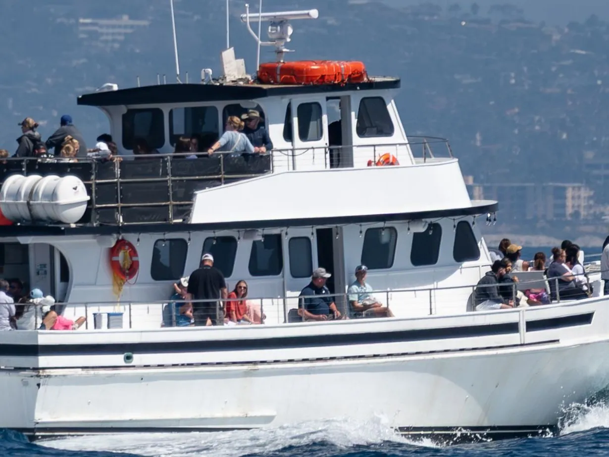Passengers on both decks of a shared boat under way